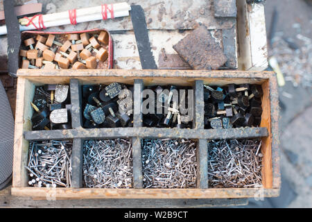 Gli utensili di ciottoli sono disposti ordinatamente in scomparti di legno in modo da è facile cercare l'articolo. Chinatown, singapore Foto Stock