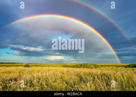 Rainbow oltre il cielo in tempesta in campagna al giorno di estate Foto Stock