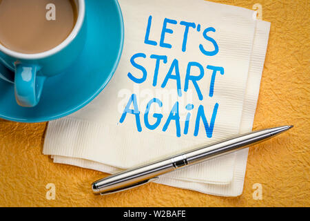 Cominciamo di nuovo nota - grafia motivazionale su un tovagliolo con una tazza di caffè Foto Stock