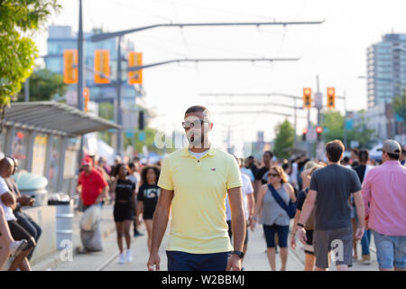 Toronto, Ontario / Canada - 7 Luglio 2019: uomo cammina attraverso la folla in quindicesima TD Salsa di St Clair Street Festival Foto Stock