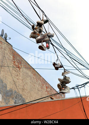 Lancia le scarpe 'shoefitti' su linee di alimentazione a Brooklyn, NY (verticale) Foto Stock