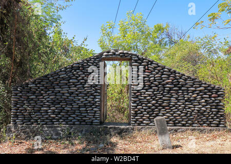 Una parete di boulder con aprire porte in legno. Muro di pietra dalla strada nell isola di Bali, Indonesia. Immettere la giungla. Luogo mistico con edificio misterioso. Foto Stock