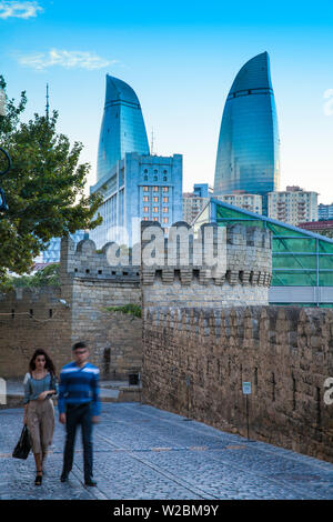 Azerbaigian, Baku, in vista delle mura della città vecchia e le torri a fiamma di notte Foto Stock