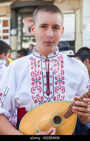 La Bulgaria, centrale Monti, Kazanlak, Kazanlak Rose Festival, citta' produce il 60% di tutto il mondo di olio di rose, giovane uomo in costume tradizionale con il mandolino, NR Foto Stock