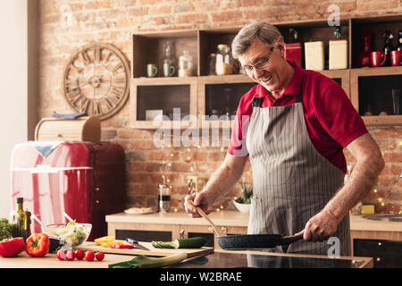 Cura Uomo senior prepara la colazione in cucina Foto Stock
