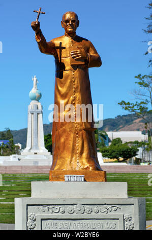 San Salvador El Salvador, Dawn, Salvatore del mondo Plaza, statua dell Arcivescovo Oscar Romero, ufficioso Patrona di El Salvador, assassinato all'inizio del paese la guerra civile nel 1980, sullo sfondo il monumento al Divino Salvatore del mondo, Monumento al Divino Salvador Del Mundo, Statua di Gesù Cristo in piedi su una sfera globale del pianeta Terra, identifica e rappresenta El Salvador e Salvadorians in tutto il mondo Foto Stock