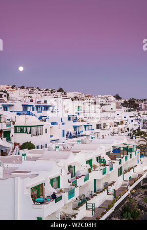 Spagna Isole Canarie Lanzarote, Puerto del Carmen, case al mare e il sorgere della luna, crepuscolo Foto Stock