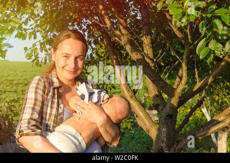 La madre e il bambino in un giardino verde Foto Stock