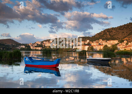 La Grecia, Macedonia occidentale Regione, Kastoria, vista città dal lago Orestiada, dawn, con il lago di barche da pesca Foto Stock