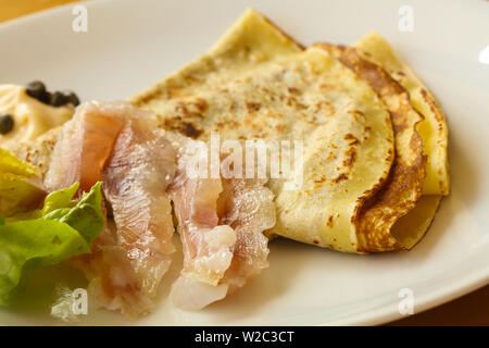 Gravlax con pancake servita foglie di insalata Foto Stock