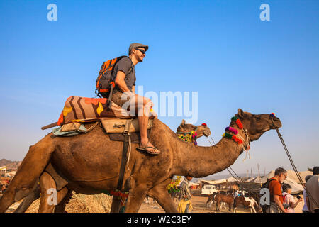 India Rajasthan, Pushkar, turisti in giro in cammello a Pushkar Camel Fair Foto Stock