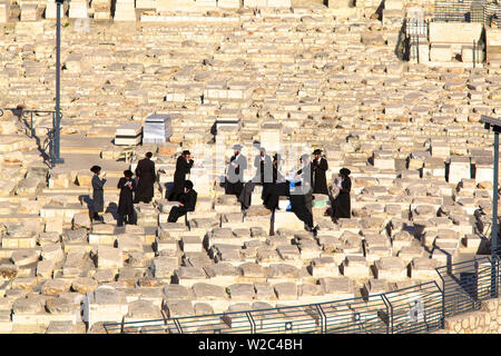 Gli ebrei ortodossi pregando sulla tomba, cimitero ebraico, il monte degli Ulivi, Gerusalemme, Israele, Medio Oriente Foto Stock