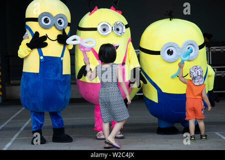 Ragazzo e ragazza che gioca con la divertente giallo ragazzi a un pubblico di bambini dell'evento in Vietnam Foto Stock