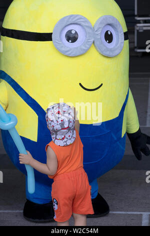 Ragazzo e ragazza che gioca con la divertente giallo ragazzi a un pubblico di bambini dell'evento in Vietnam Foto Stock