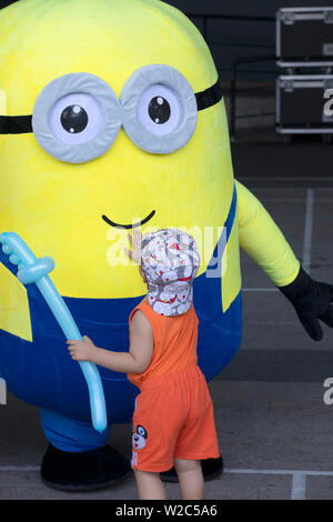 Ragazzo e ragazza che gioca con la divertente giallo ragazzi a un pubblico di bambini dell'evento in Vietnam Foto Stock