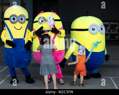 Ragazzo e ragazza che gioca con la divertente giallo ragazzi a un pubblico di bambini dell'evento in Vietnam Foto Stock