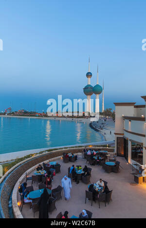 Il Kuwait Kuwait City, Sharq, persone mangiare fuori al ristorante vicino a Kuwait Towers sul Golfo Arabico Street Foto Stock