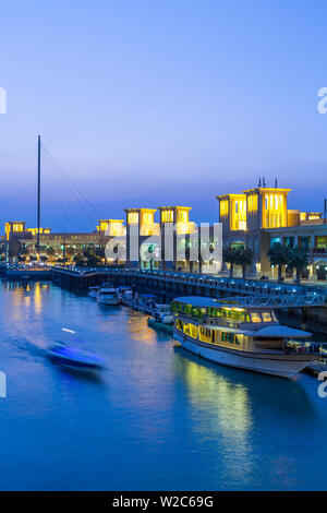Il Kuwait Kuwait City, Souk Shark Mall e Kuwait Harbour, illuminate al tramonto Foto Stock