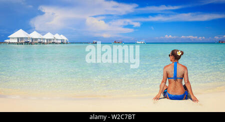 Maldive, South Ari Atoll, Athuruga Island, Diamanti Athuruga Resort, giovane donna sulla spiaggia (MR) Foto Stock