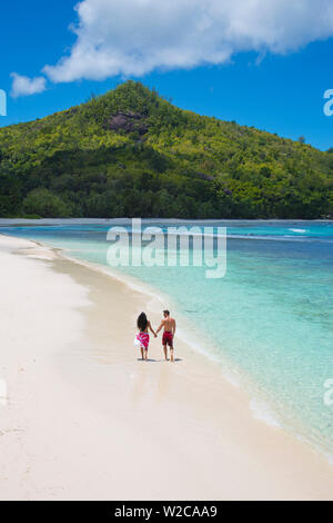 Giovane camminando lungo la spiaggia, Mahe, Seychelleshands Foto Stock