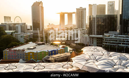 Vista in elevazione sopra il quartiere degli intrattenimenti di Clarke Quay, del Fiume Singapore e dello skyline della città di sunrise, Singapore Foto Stock