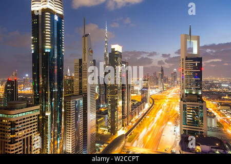 Crepuscolo & vista in elevazione oltre i moderni grattacieli lungo la Sheikh Zayed Road guardando verso il Burj Kalifa, Dubai, Emirati Arabi Uniti Foto Stock