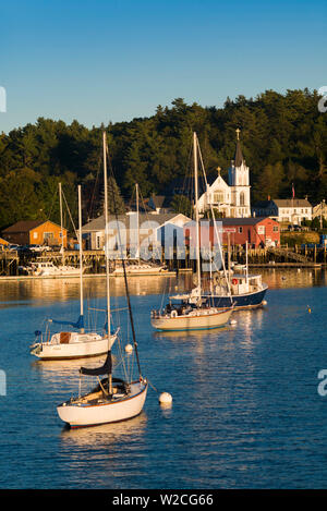 Stati Uniti d'America, Maine, Boothbay Harbor, la vista del porto con la Nostra Signora Regina della pace chiesa cattolica, tramonto Foto Stock