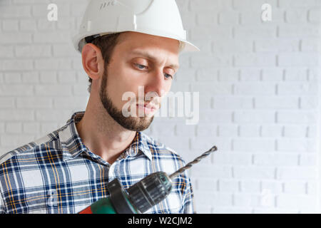 Repairman lavora con il trapano elettrico Foto Stock