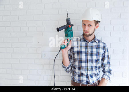 Ritratto di un costruttore tenendo un trapano Foto Stock