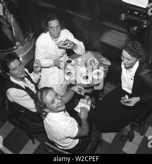 1940s Fika . Quattro giovani donne che lavorano al caffè Röda rummet a Stoccolma sono seduti insieme e hanno una tazza di caffè e tè. Svezia. Foto Kristoffersson Ref 215-2. Svezia 1941 Foto Stock