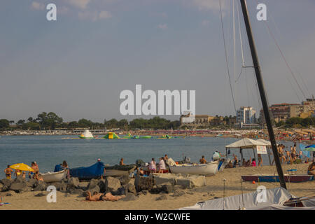 Giardini Naxos Sicilia Italia 2019 vista la lunga spiaggia con barche, il porto turistico e il bellissimo mare popolare in estate Foto Stock