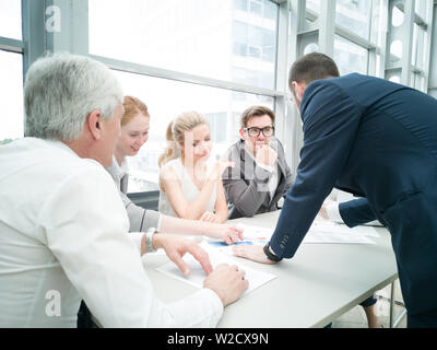 Un gruppo di uomini di affari che discutere di diagrammi in Office insieme Foto Stock