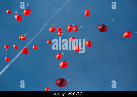 Molti battenti rosso a forma di cuore palloncini in cielo blu al matrimonio, contrail Foto Stock