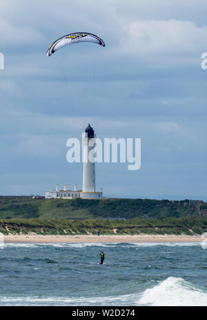 Il 7 luglio 2019. Lossiemouth West Beach, murene, Scotland, Regno Unito. Questa è la persona kite boarding in mare nei pressi di Covesea faro in Moray costa. Foto Stock