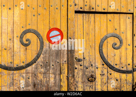 Vecchio ferro curvo delle cerniere sulla porta del garage - Francia. Foto Stock