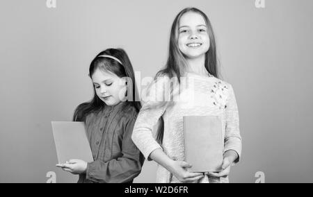 Sorelle pick libri da leggere insieme. Adorabili ragazze amano i libri. Diari segreti o un diario personale. Smart è grande. I ragazzi ragazze con libri e quaderni. Educazione e letteratura per bambini. Favola preferita. Foto Stock