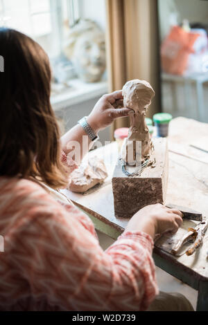 Signora scultore lavorando nel suo studio, ceramis artista con le mani in mano la realizzazione di oggetti di argilla naturale Foto Stock