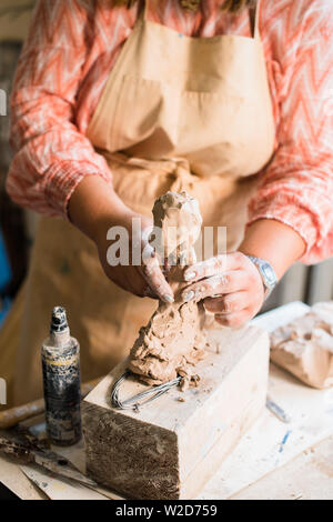 Signora scultore lavorando nel suo studio, ceramis artista con le mani in mano la realizzazione di oggetti di argilla naturale Foto Stock