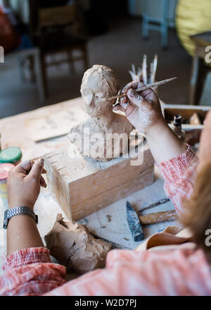 Signora scultore lavorando nel suo studio, ceramis artista con le mani in mano la realizzazione di oggetti di argilla naturale Foto Stock