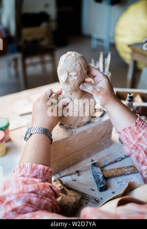 Signora scultore lavorando nel suo studio, ceramis artista con le mani in mano la realizzazione di oggetti di argilla naturale Foto Stock