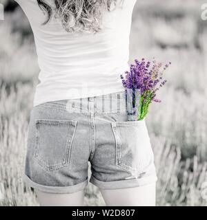 Bouquet di viola Lavanda fiori nella tasca dei jeans. Foto in bianco e nero, luminoso bouquet. Spazio di copia Foto Stock