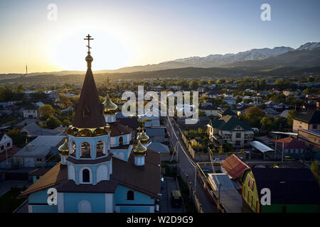 Chiesa ortodossa di sunrise sullo sfondo di alte montagne di Almaty, Kazakhstan Foto Stock