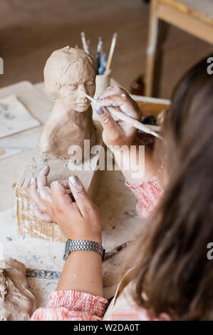 Signora scultore lavorando nel suo studio, ceramis artista con le mani in mano la realizzazione di oggetti di argilla naturale Foto Stock