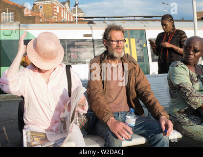 Vagabondo a parlare con se stesso a Clapham Junction stazione di Londra Foto Stock