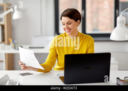 Donna creativa lavorando su interfaccia utente in ufficio Foto Stock