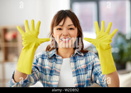 Donna asiatica nei guanti di gomma la pulizia a casa Foto Stock