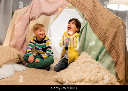 Felice ragazzi con torcia luce in tenda per bambini a casa Foto Stock