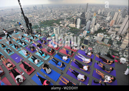 Bangkok, Tailandia. 7 Luglio, 2019. Gli appassionati di Yoga frequentare il vino sunrise yoga classe presso la terrazza sul tetto di Mahanakhon skywalk a Bangkok, Thailandia, Luglio 7, 2019. Vino di sunrise yoga unisce la gioia di bere il vino con lo yoga tradizionale pone mentre il bilanciamento delle bevande, sorseggiando e tostatura. Credito: Rachen Sageamsak/Xinhua/Alamy Live News Foto Stock