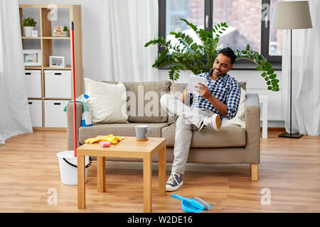 Uomo indiano rendendo Lista da fare dopo la pulizia della casa Foto Stock