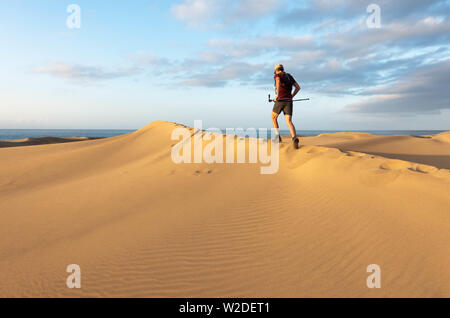 62 enne trail runner il training su vaste dune di sabbia a Maspalomas a Gran Canaria a sunrise. Foto Stock